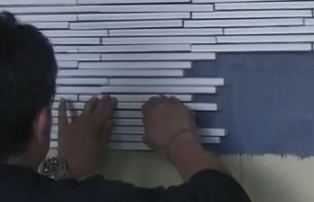 Squeeze tiles to adhesive and push up any individual tiles